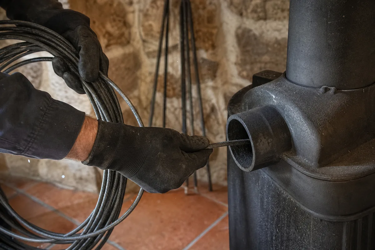 Ramoneur passant un hérisson dans le conduit de fumée d&rsquo;une maison de pierre bourguignonne